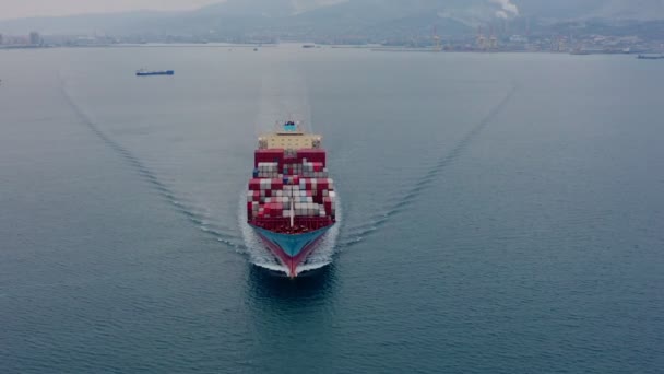 Aerial view of seagoing vessel with numerous containers sailing on a calm sea — Stock Video
