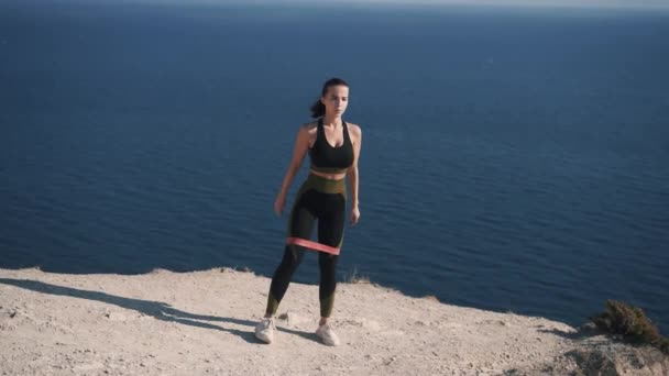 Zeitlupe schlanke junge Frau in Sportbekleidung macht Kniebeugen — Stockvideo