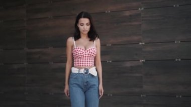 Kendine güvenen beyaz tenli güzel esmer model kameraya doğru yürüyor.