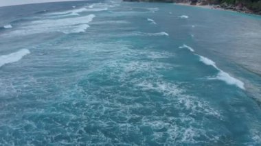 Havadan bakıldığında büyüleyici köpüklü mavi deniz dalgaları yükseliyor