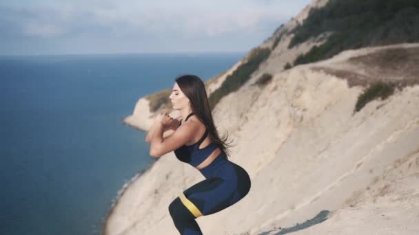 Sexy jovem esportivo mulher exercitando com uma faixa elástica — Vídeo de Stock