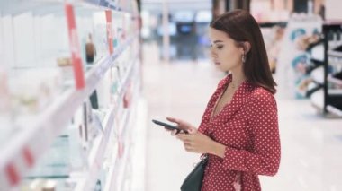 Güzel genç esmer kız dükkanda ürünlerin fotoğraflarını çekiyor.