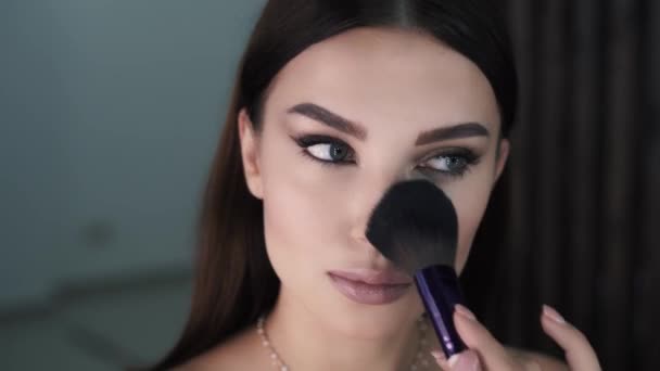 Primer plano de chica morena bastante joven aplicando maquillaje usando cepillo — Vídeo de stock