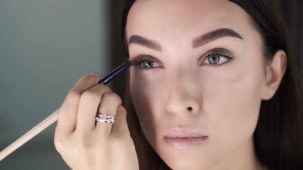 Donna make-up artist applica ombretto e lo distribuisce — Video Stock
