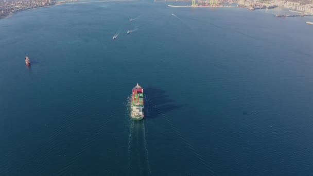 Вид с воздуха на большой контейнерный корабль, плавающий в спокойных океанских волнах — стоковое видео