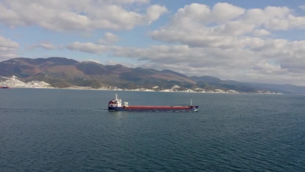 Kargo gemisinin limandaki sakin denizde yüzüşünün insansız hava aracı görüntüleri. — Stok video