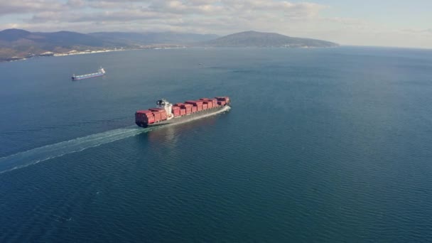 Надзвичайно великий завантажений контейнерний корабель, що плаває у відкритому океані, вигляд з повітря — стокове відео