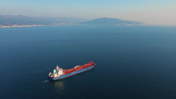 Widok z powietrza na duży statek towarowy opuszczający port morski w słoneczny dzień — Wideo stockowe