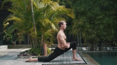 Kafkasyalı spor adamı yoga yapıyor ve kaslarını esnetiyor..
