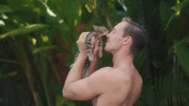 Brutal and strong caucasian man plays with nice little kitten — Stock Video