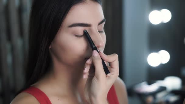 Hand tillämpa ljusare skuggor på ögonlock av kaukasisk vacker kvinna — Stockvideo