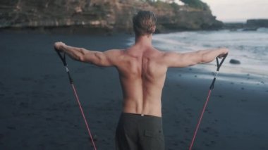 Geniş omuzlu elastik bantlı vücut geliştiricinin arka planı.