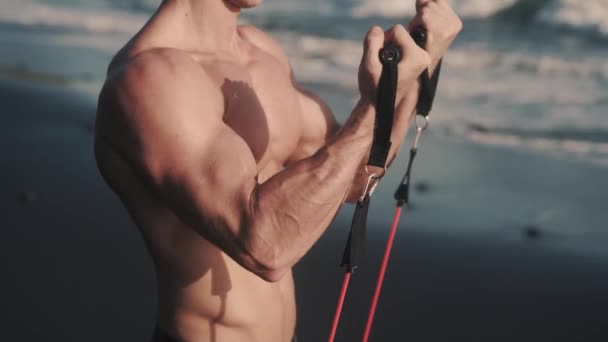 Primer plano de vídeo de fuertes músculos pectorales y bíceps funciona con banda elástica. — Vídeos de Stock