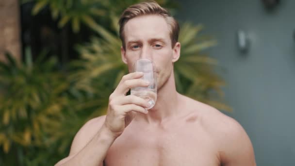 Close up portrait of caucasian man drinks fresh water. — Stock Video