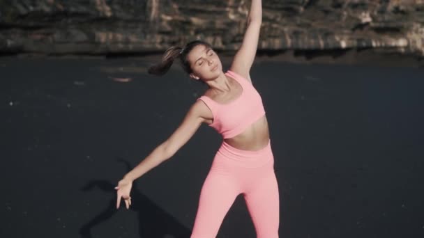 Vue de face de la jeune femme faisant des exercices matinaux au bord de la mer. — Video