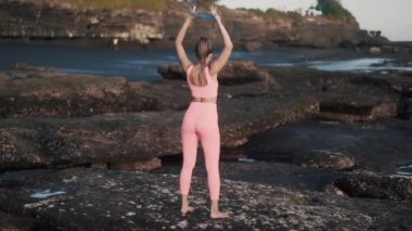 Arka plan seksi kadın mavi elastik bantla dışarıda egzersiz yapıyor..