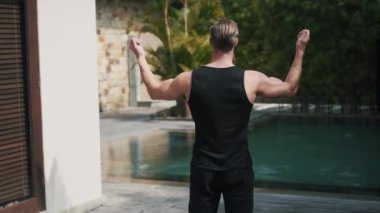 Fitness sporu Kafkasyalı erkek havuz başında doğada ısınıyor.