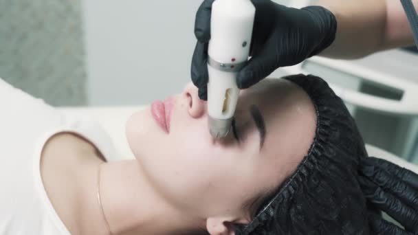 Ung vacker kvinna tar en icke-injektion mesotherapy på vackert ansikte. — Stockvideo