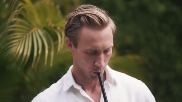Porträtt av ung vacker man rökning hookah i slow motion. — Stockvideo