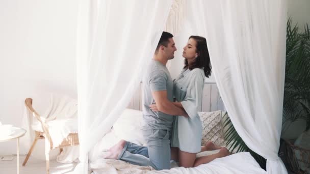 Vídeo en cámara lenta de una joven pareja coqueteando abrazándose en la cama. — Vídeo de stock