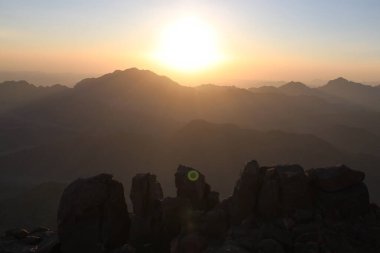 Mısır 'ın en yüksek dağı olan Musa Dağı' nın tepesinde güneş doğuyor. Tasarımınız için bir fikir.