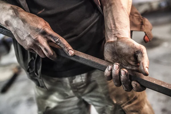 Schmutzige Hände mit Hex-Metallstab — Stockfoto