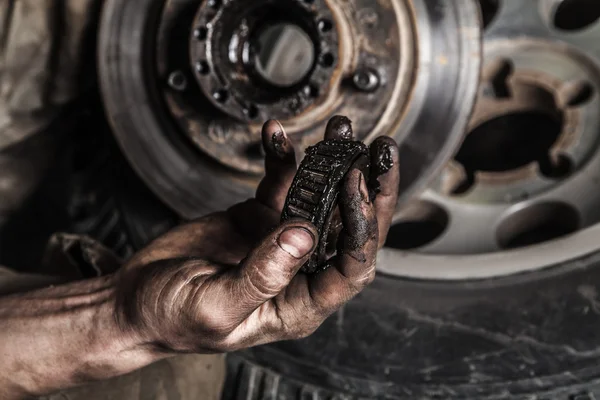Dirty man hand with gear — Stock Photo, Image