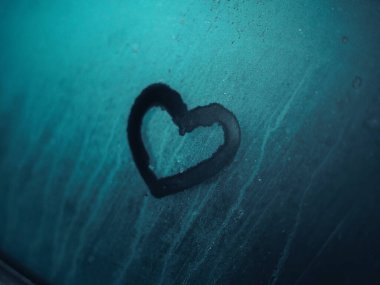 Derin Koyu Turkuaz Renkli Donmuş bir yüzeye çizilen Kalp Şekli Duygusal Sembolizm ile Zengin Serin Tonu Minimalist Kış Konsepti Oluşturur