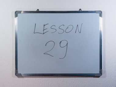 Eğitim içeriğini, öğrenim yapısını ve öğretim yöntemini temsil eden temiz beyaz duvar arkaplanı üzerine LESSON kavramını gösteren beyaz tahta