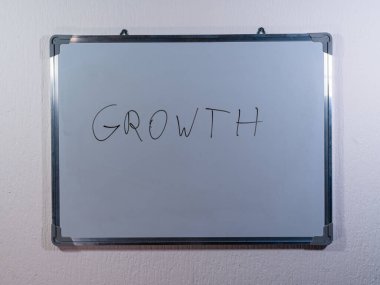 Beyaz tahta, iş genişletme, gelişme ve başarıyı temsil eden temiz beyaz duvar arkaplanı üzerinde GROWTH kavramını gösterir