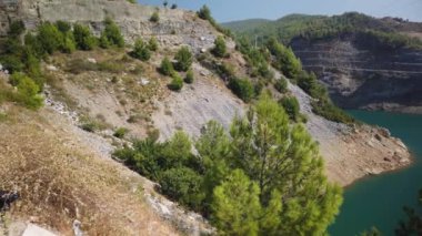 Bir dağ ormanı gölünde çam ağaçlarıyla birlikte turkuaz su. Türk peyzaj çam ormanı ve Rezervuar Dim Cay