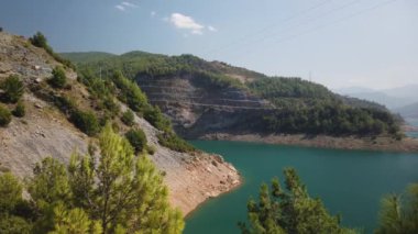 Bir dağ ormanı gölünde çam ağaçlarıyla birlikte turkuaz su. Türk peyzaj çam ormanı ve Rezervuar Dim Cay