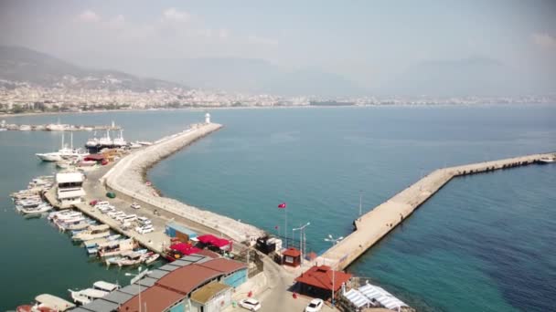 Pohled na Alanyu a přístav ve slunečný den. Pobřeží Středozemního moře a historické loděnice Alanya v Turecku. — Stock video