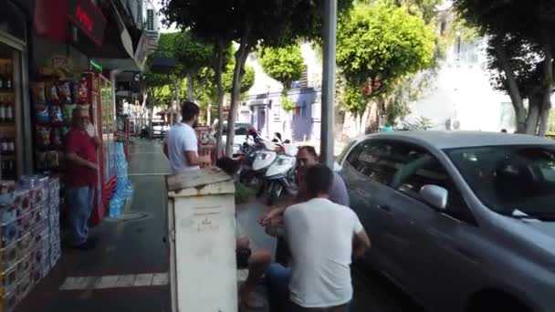 17 SEPTEMBER 2020, ALANYA, TURKEY: Wandelen langs de straat langs de geparkeerde auto 's langs boetieks, winkels en cafés in het centrum van Alanya stad. — Stockvideo