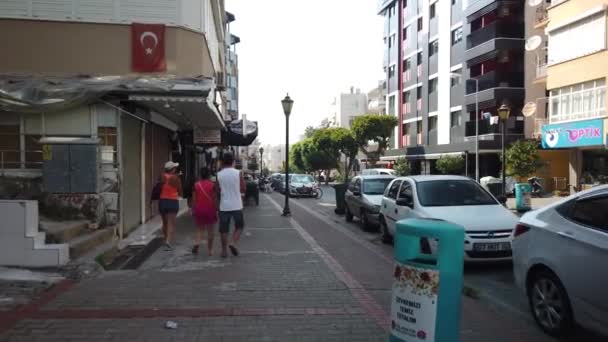 17 SEPTEMBER 2020, ALANYA, TURKEY: Wandelen langs de straat langs de geparkeerde auto 's langs boetieks, winkels en cafés in het centrum van Alanya stad. — Stockvideo