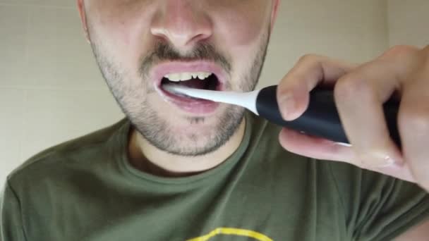 一个留胡子的男人张嘴在镜子里刷牙 电刷上的牙膏 — 图库视频影像