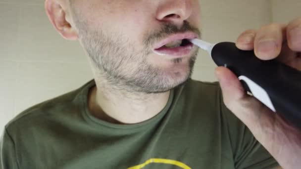 髭を生やした男が口を開けて鏡に歯を磨く 歯ブラシの上の歯磨き粉 — ストック動画
