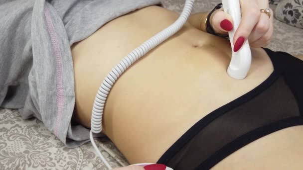 Беременная женщина крупным планом слушает звук сердца плода через карманный доплер на кровати — стоковое видео