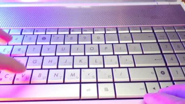 First-person view, hands type text on laptop keyboard