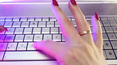 First-person view, hands type text on laptop keyboard