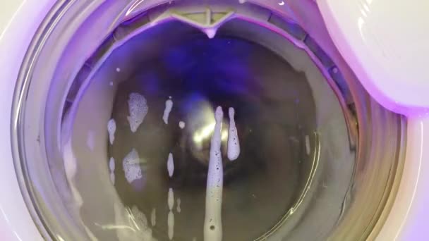白い洗濯機は汚れたカラフルな服を洗う 洗濯機で洗濯する 回転ドラム洗浄機のビデオを閉じる — ストック動画