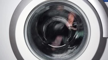 Çamaşır makinesinin varilinde bir şeyler dönüyor. Evde yıkanıyor.
