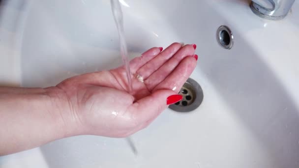 O sal de banho de bomba dissolve-se na água e cria a espuma. Uma menina segura uma bomba de banho em suas mãos. — Vídeo de Stock