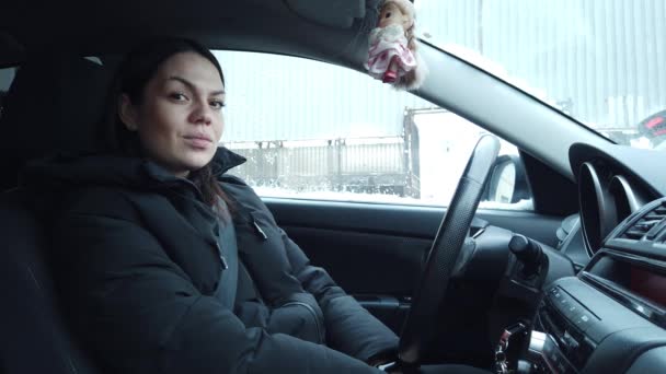 女性の肖像画 サイドビュー 道路上の女性ドライバー 若い女性はハンドルを握って街で車を運転している — ストック動画