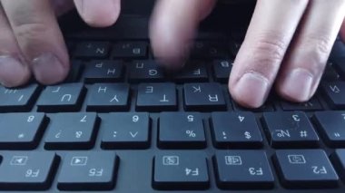 PC klavyesinde erkek eller, yakın çekim, adam hızlı bir şekilde metin yazar. Bilgisayarda ofis ya da ev işi kavramı.