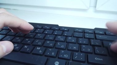 PC klavyesinde erkek eller, yakın çekim, adam hızlı bir şekilde metin yazar. Bilgisayarda ofis ya da ev işi kavramı.