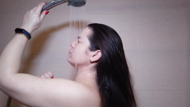 Женщина моет волосы шампунем в душе, уход за волосами, цератинная маска, ополаскивающий шампунь и бальзам, сильные волосы, мытье волос — стоковое видео