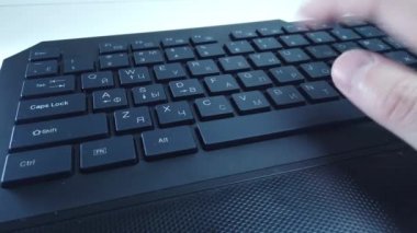 PC klavyesinde erkek eller, yakın çekim, adam hızlı bir şekilde metin yazar. Bilgisayarda ofis ya da ev işi kavramı.