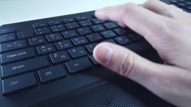 PC klavyesinde erkek eller, yakın çekim, adam hızlı bir şekilde metin yazar. Bilgisayarda ofis ya da ev işi kavramı.