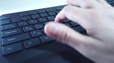 PC klavyesinde erkek eller, yakın çekim, adam hızlı bir şekilde metin yazar. Bilgisayarda ofis ya da ev işi kavramı.